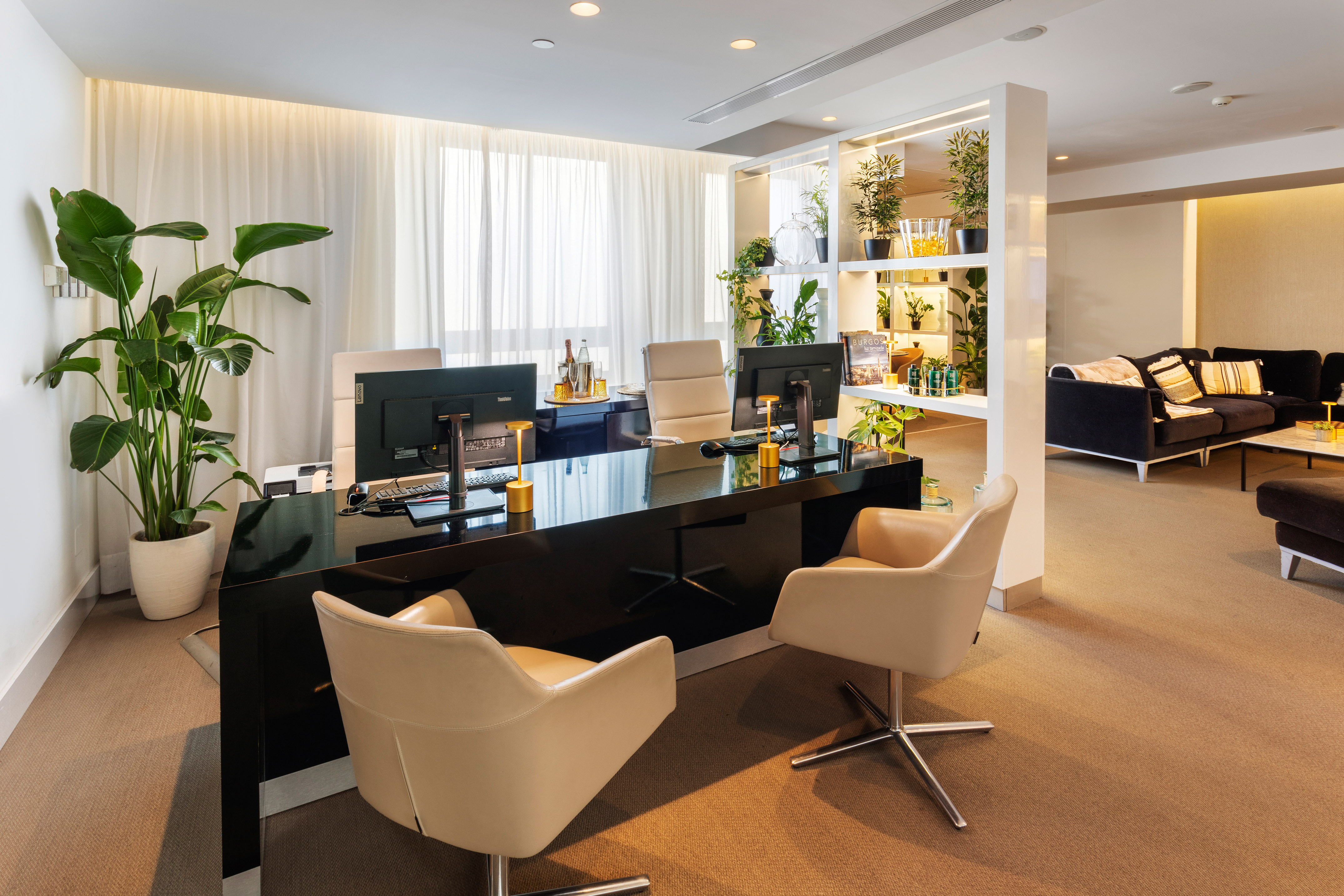 a room with a black desk and chairs