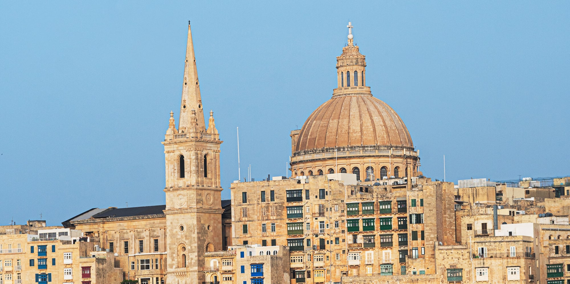 a city with a steeple and a stone wall