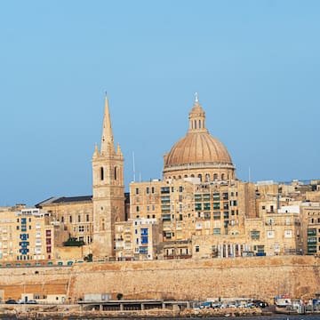 a city with a steeple and a stone wall