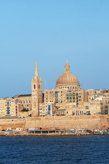 a city with a steeple and a stone wall