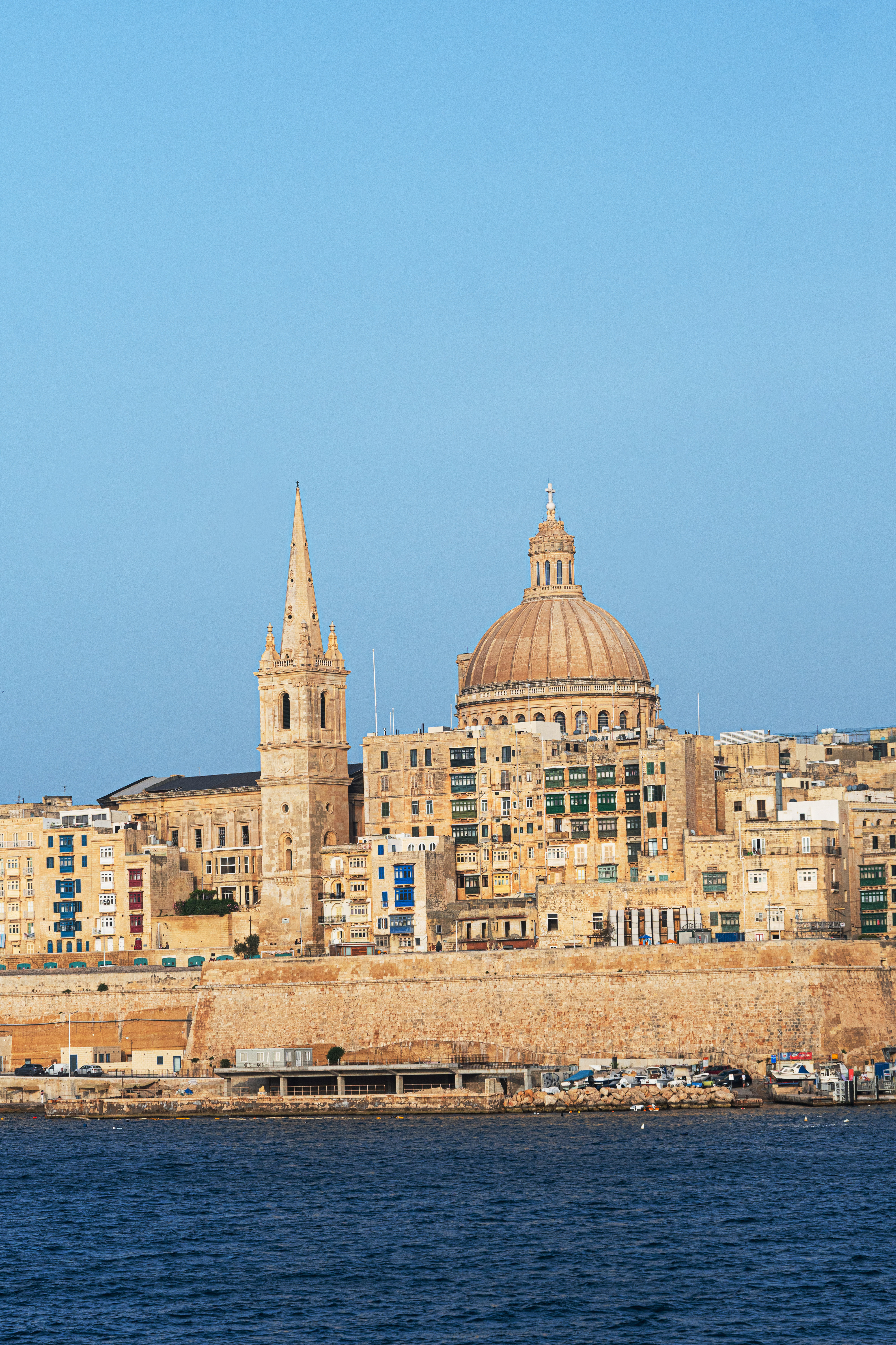 a city with a steeple and a stone wall