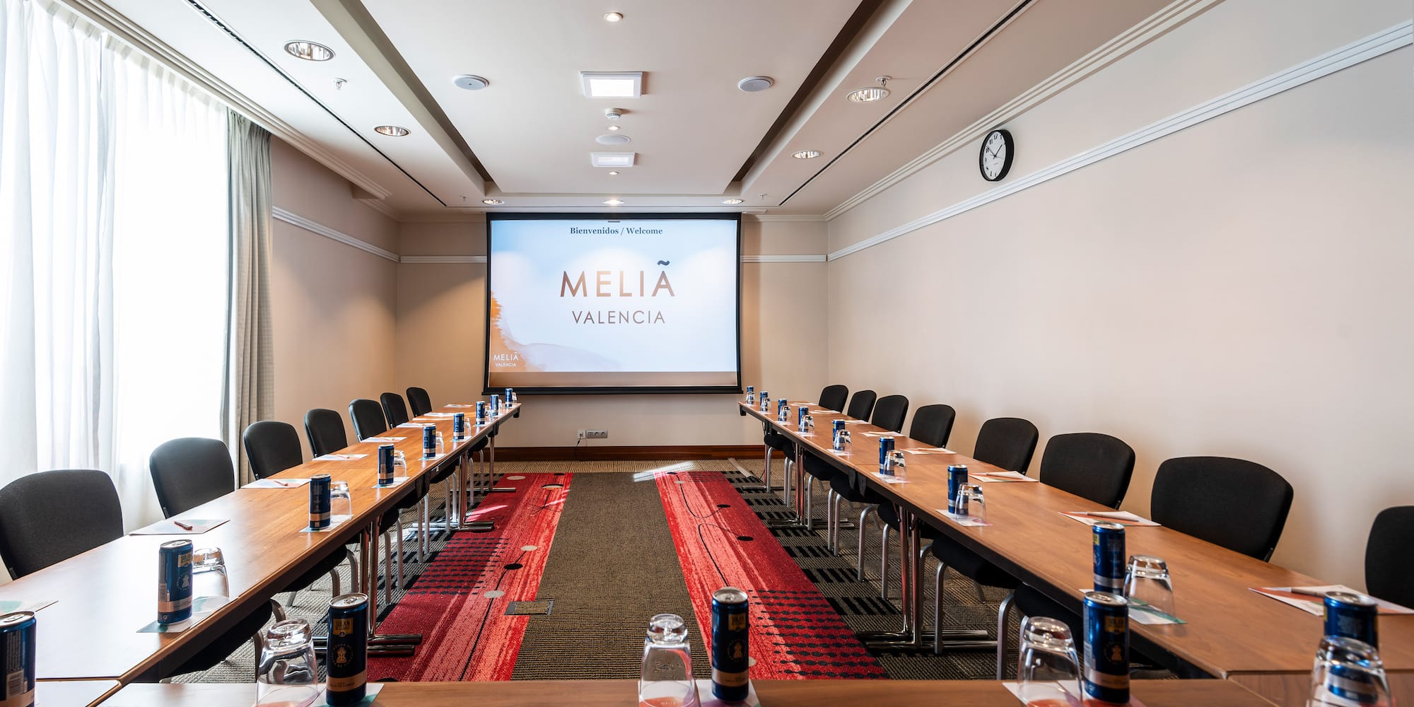 a room with tables and chairs and a projector screen