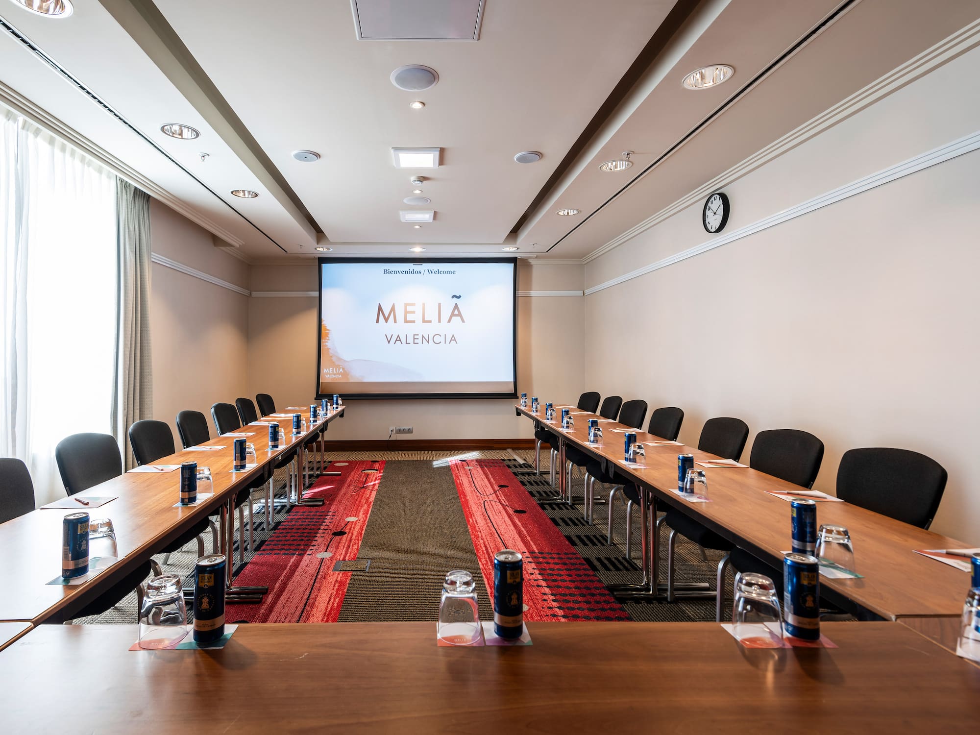 a room with tables and chairs and a projector screen