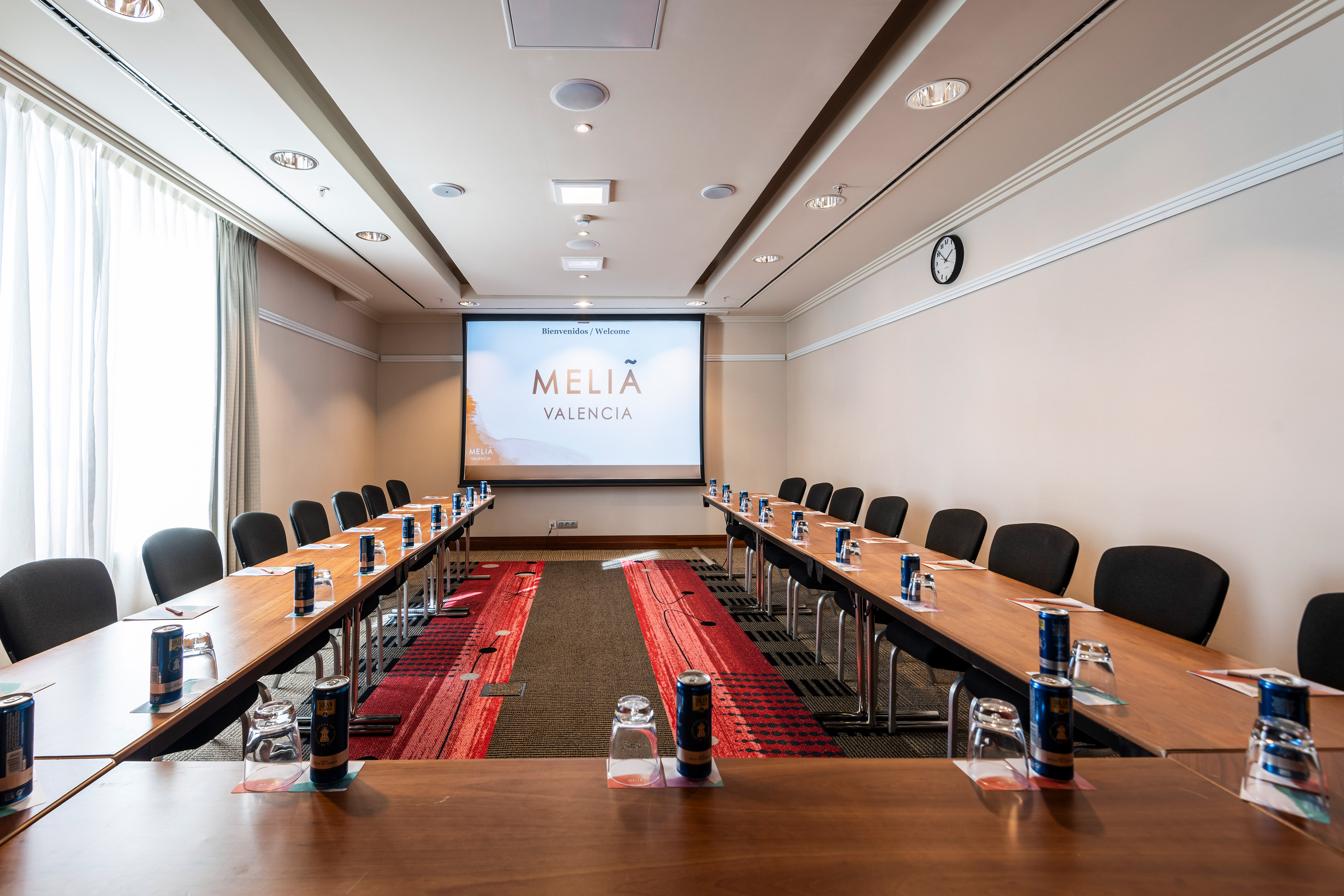 a room with tables and chairs and a projector screen