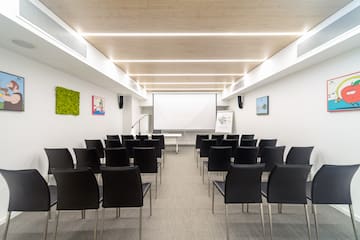 a room with chairs and a projector screen