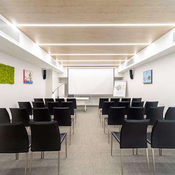 a room with chairs and a projector screen