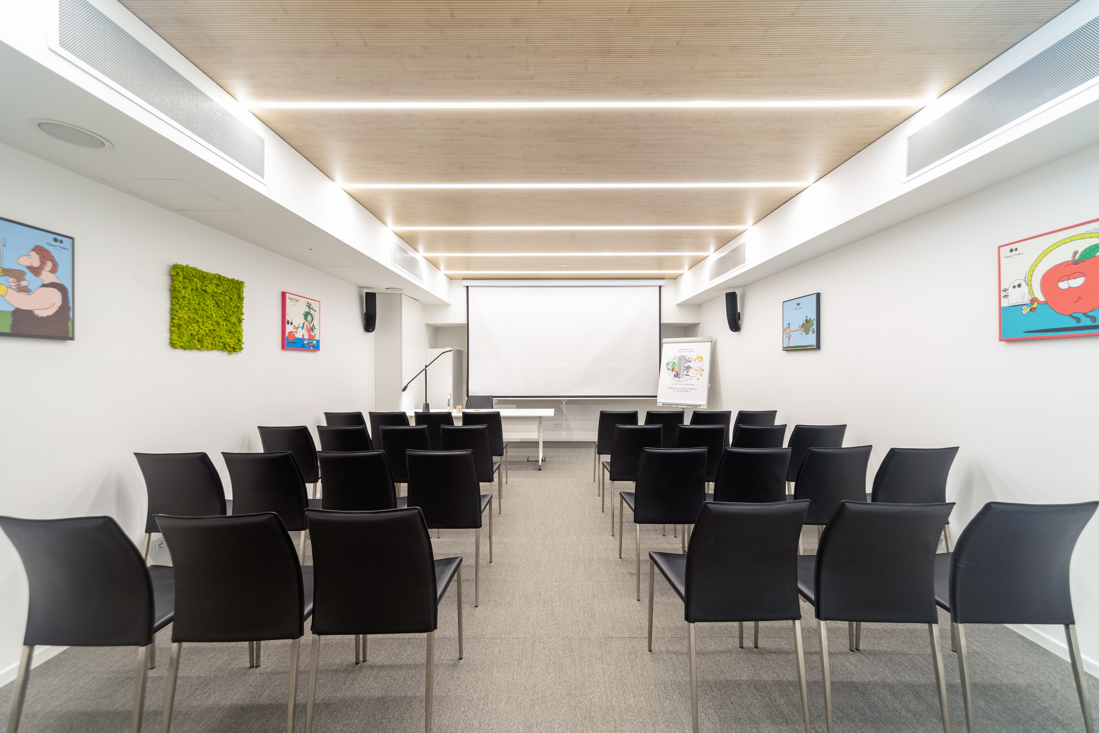 Empty modern conference room with black chairs, projector screen, and wood ceiling.