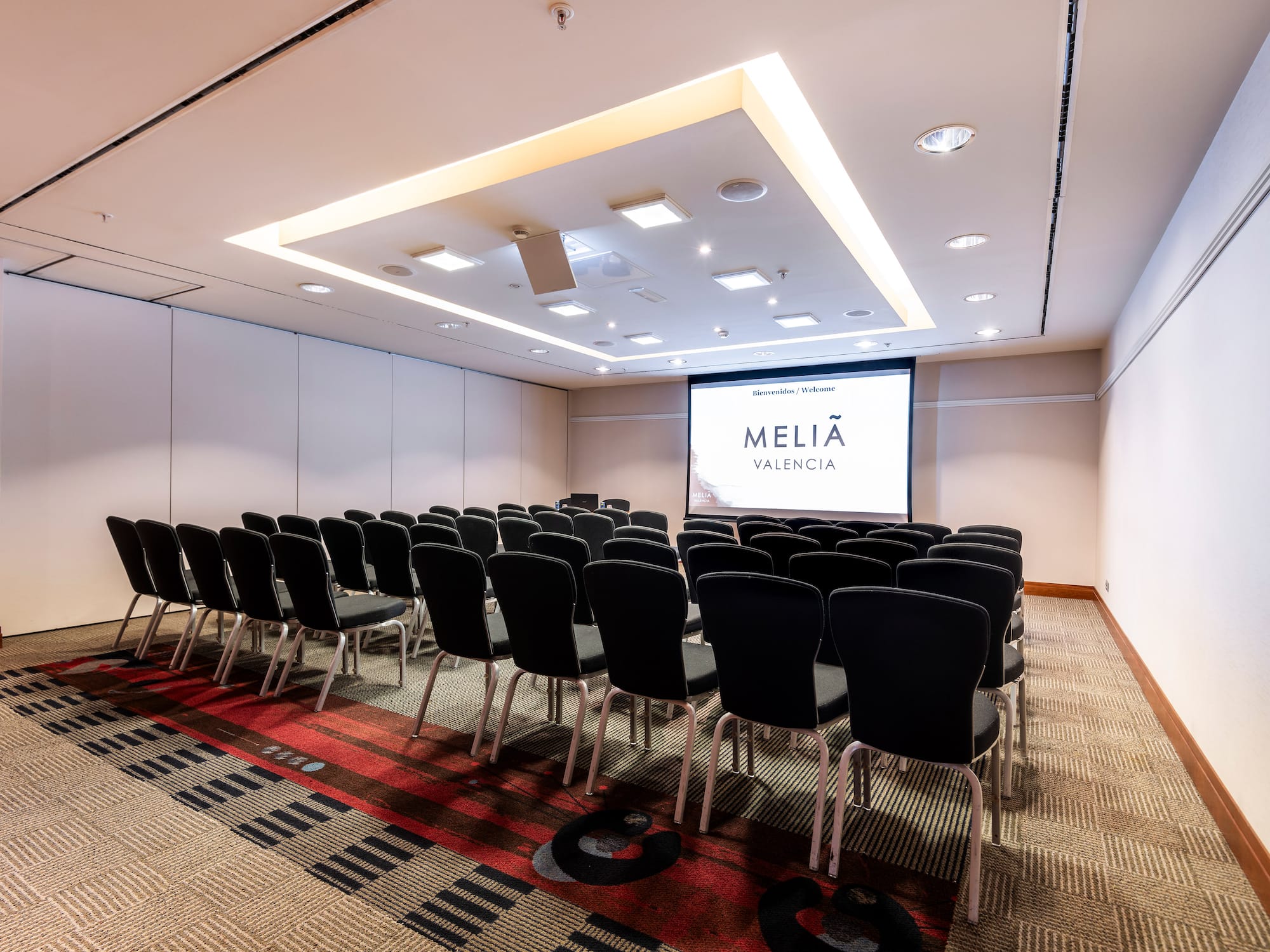 a room with chairs and a projector screen