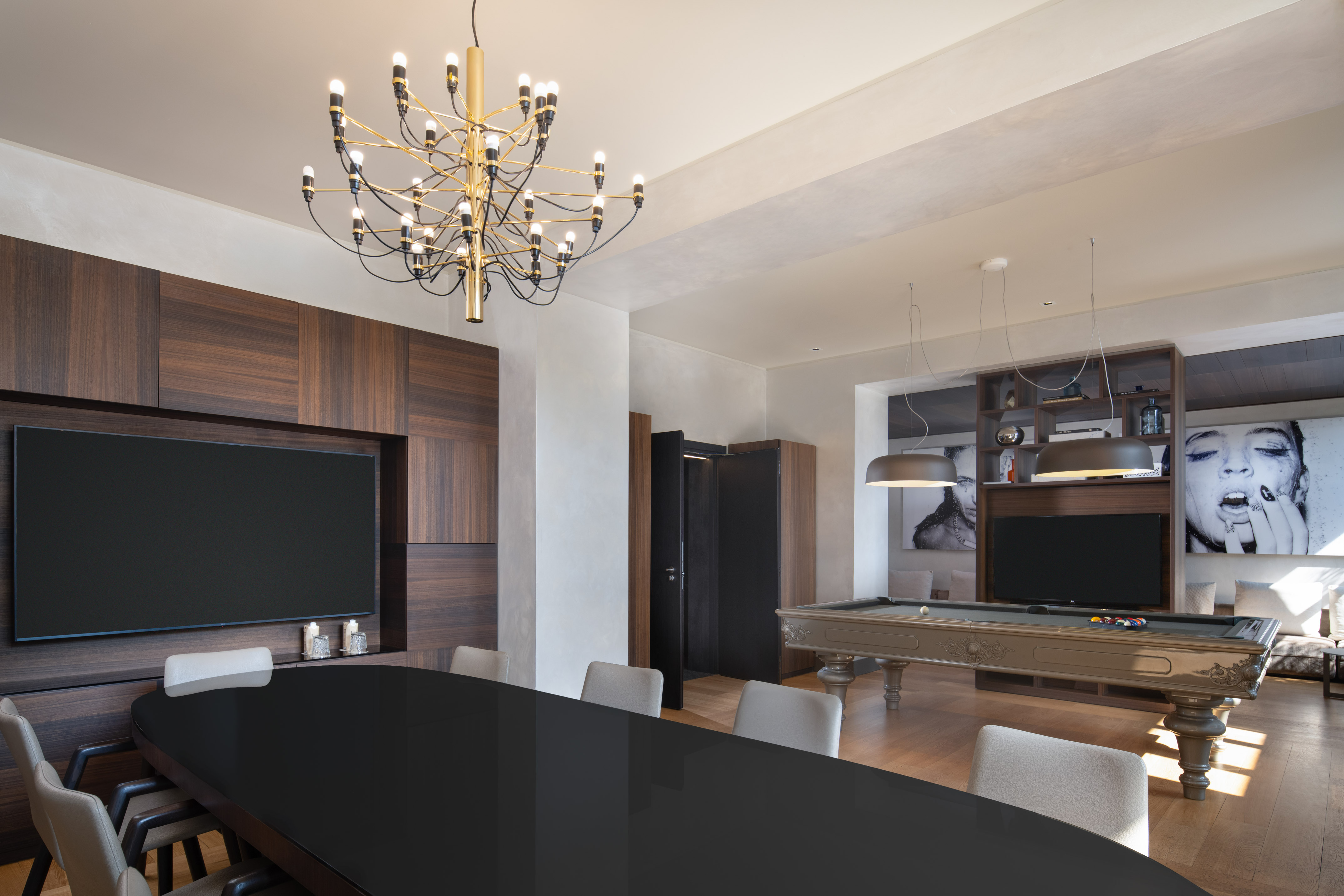 Modern entertainment room with billiard table, large TV, and sleek dining area.