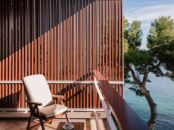 a chair on a balcony overlooking water