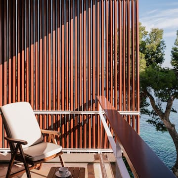 a chair on a balcony overlooking water