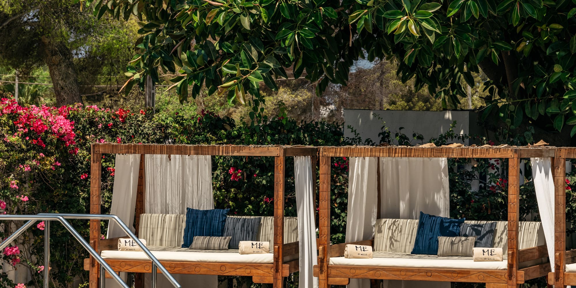 a pool with a couple of beds and a metal railing