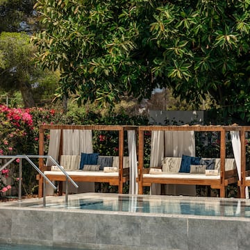 a pool with a couple of beds and a metal railing