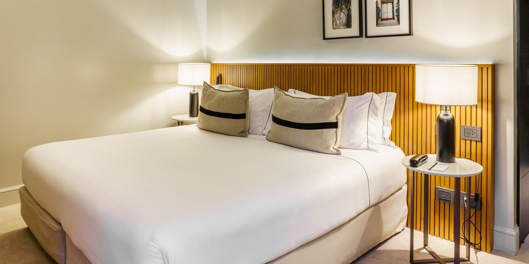 a bed with white sheets and pillows