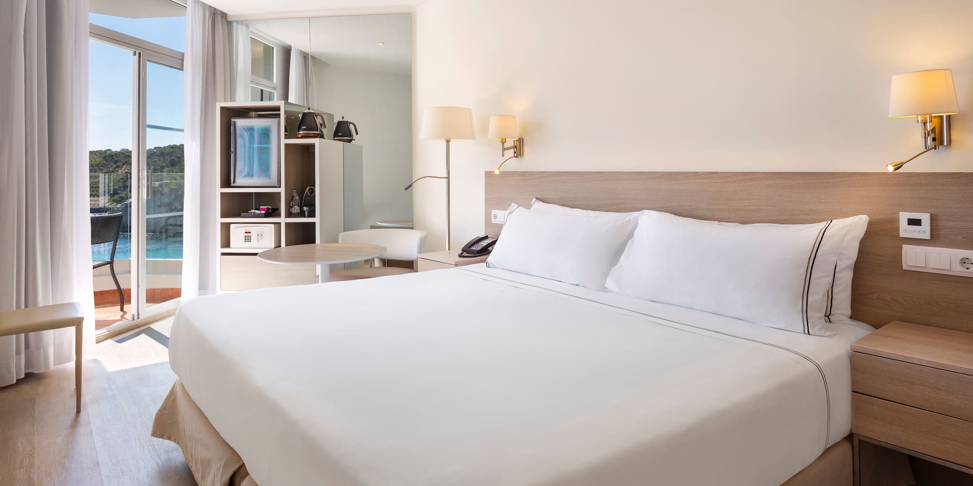 a bed with white sheets and a lamp