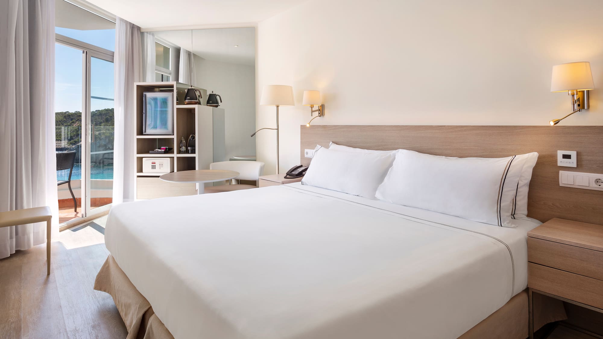 a bed with white sheets and a lamp