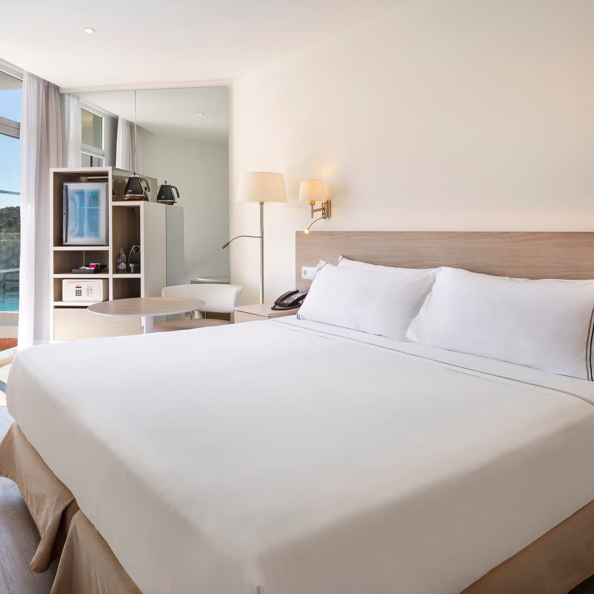 a bed with white sheets and a lamp