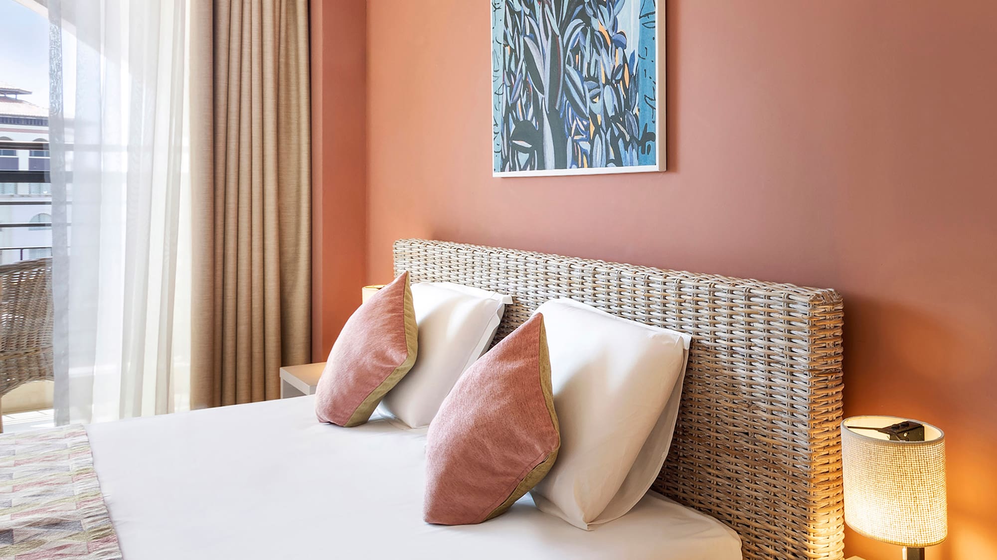 a bed with pillows and a lamp on the side of the bed