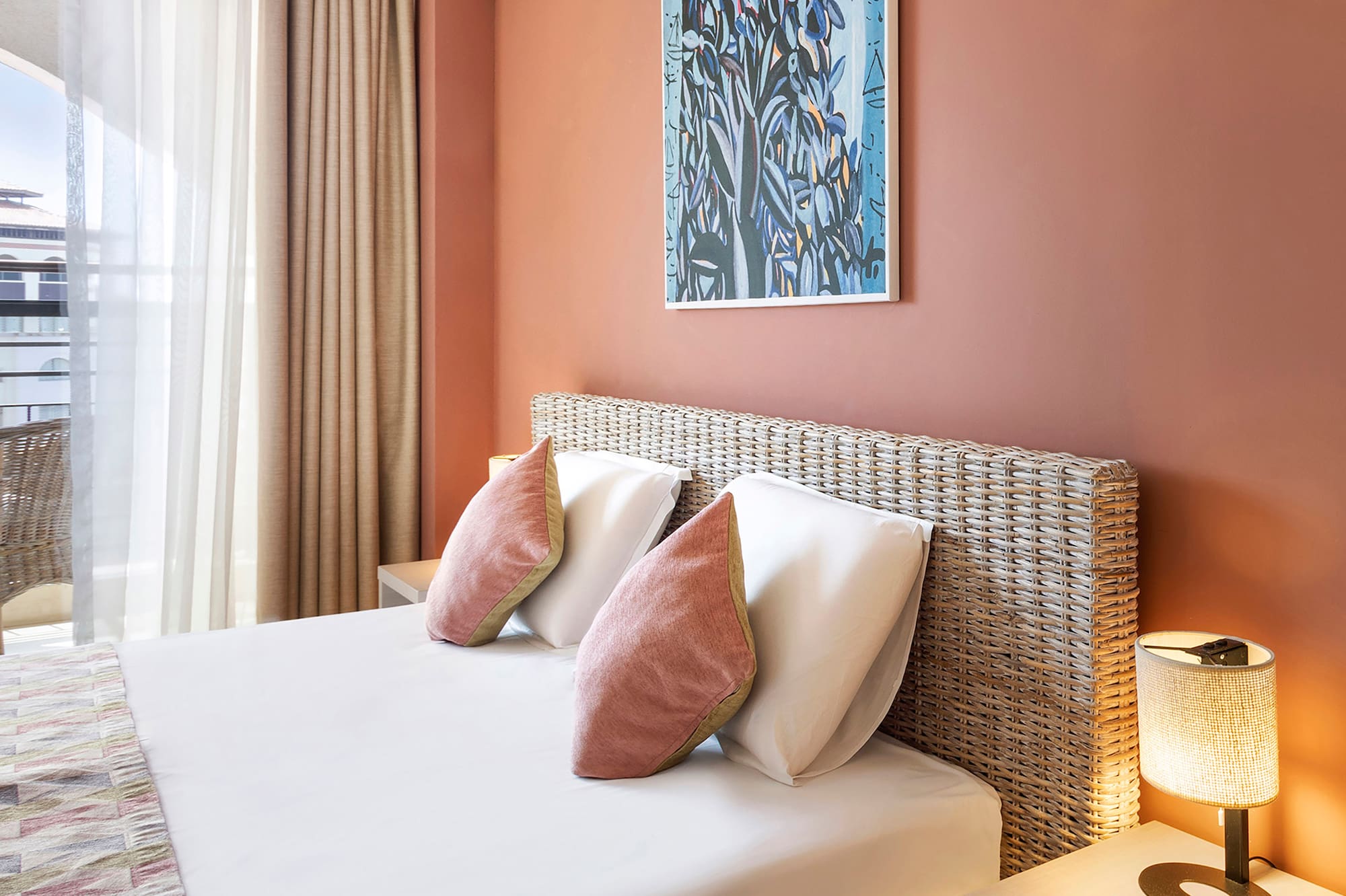 a bed with pillows and a lamp on the side of the bed