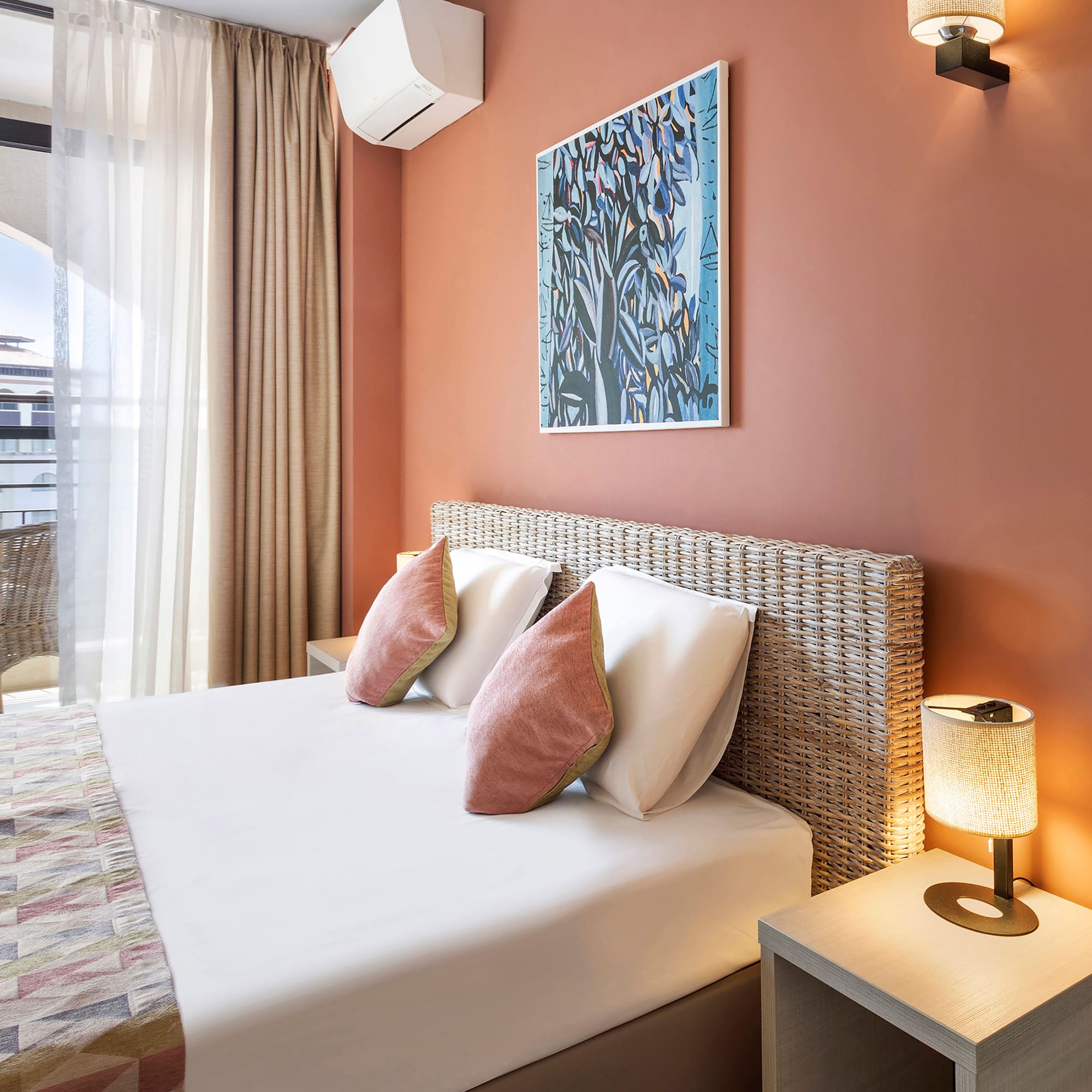 a bed with pillows and a lamp on the side of the bed