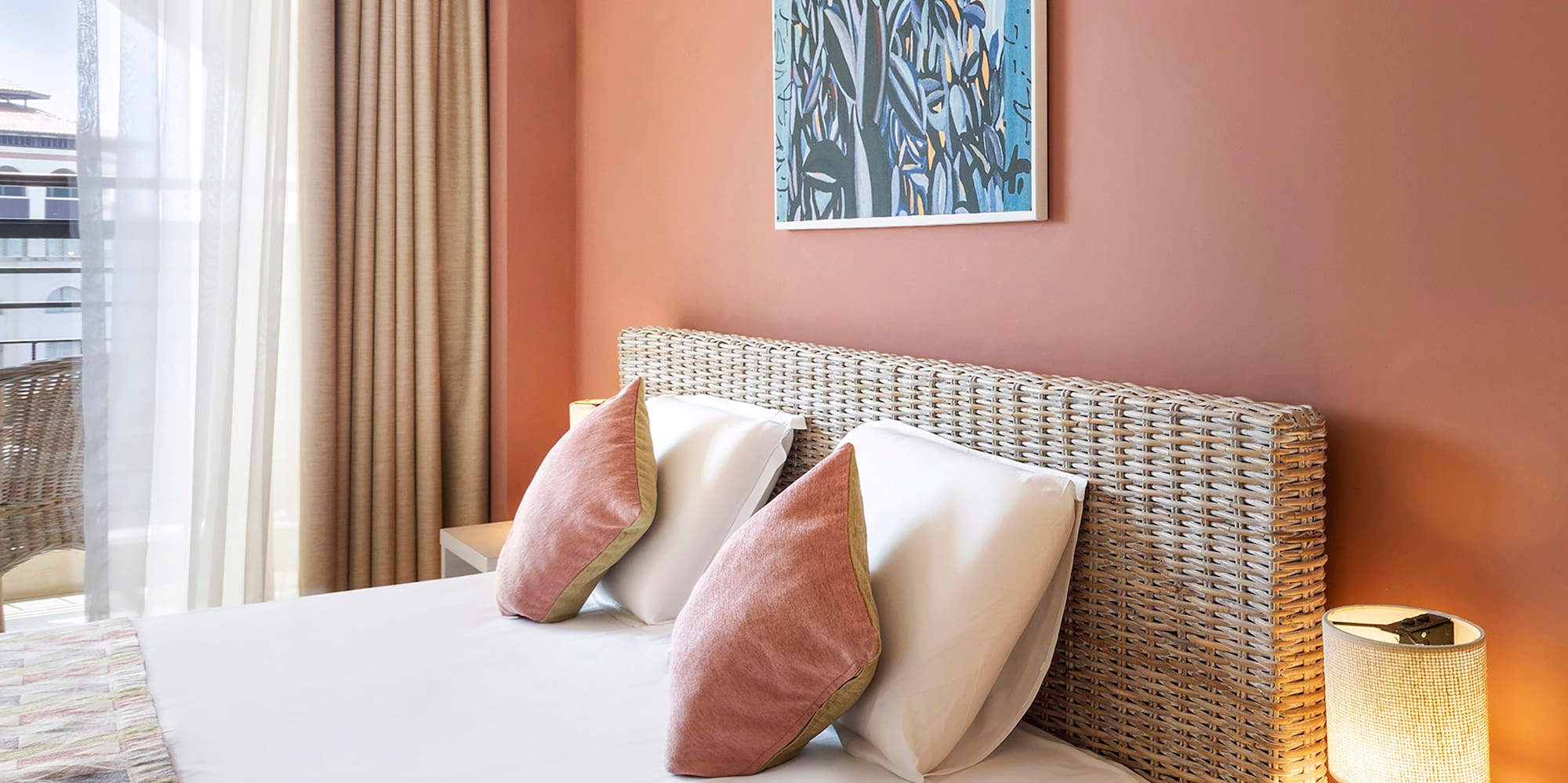 a bed with pillows and a lamp on the side of the bed