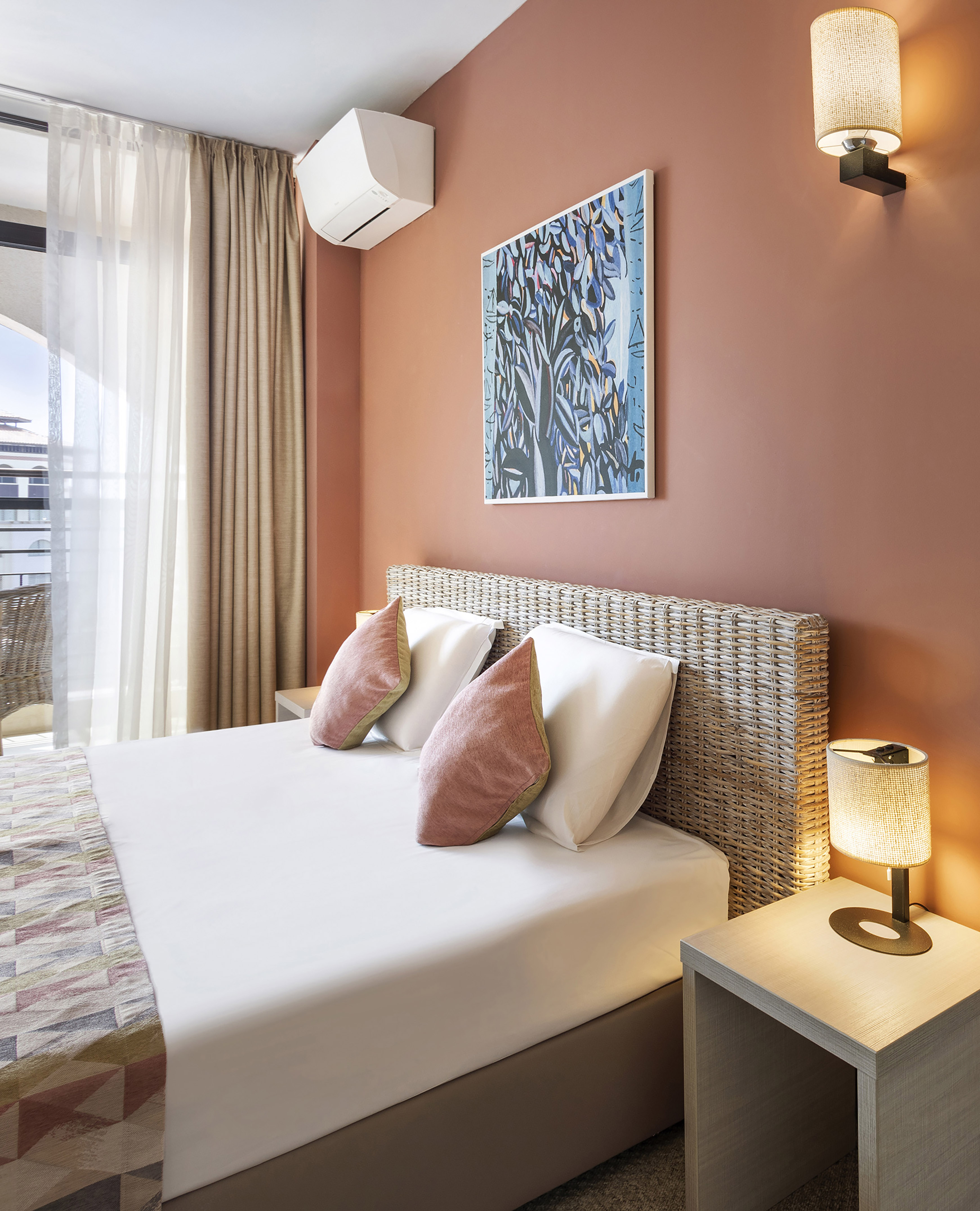 a bed with pillows and a lamp on the side of the bed