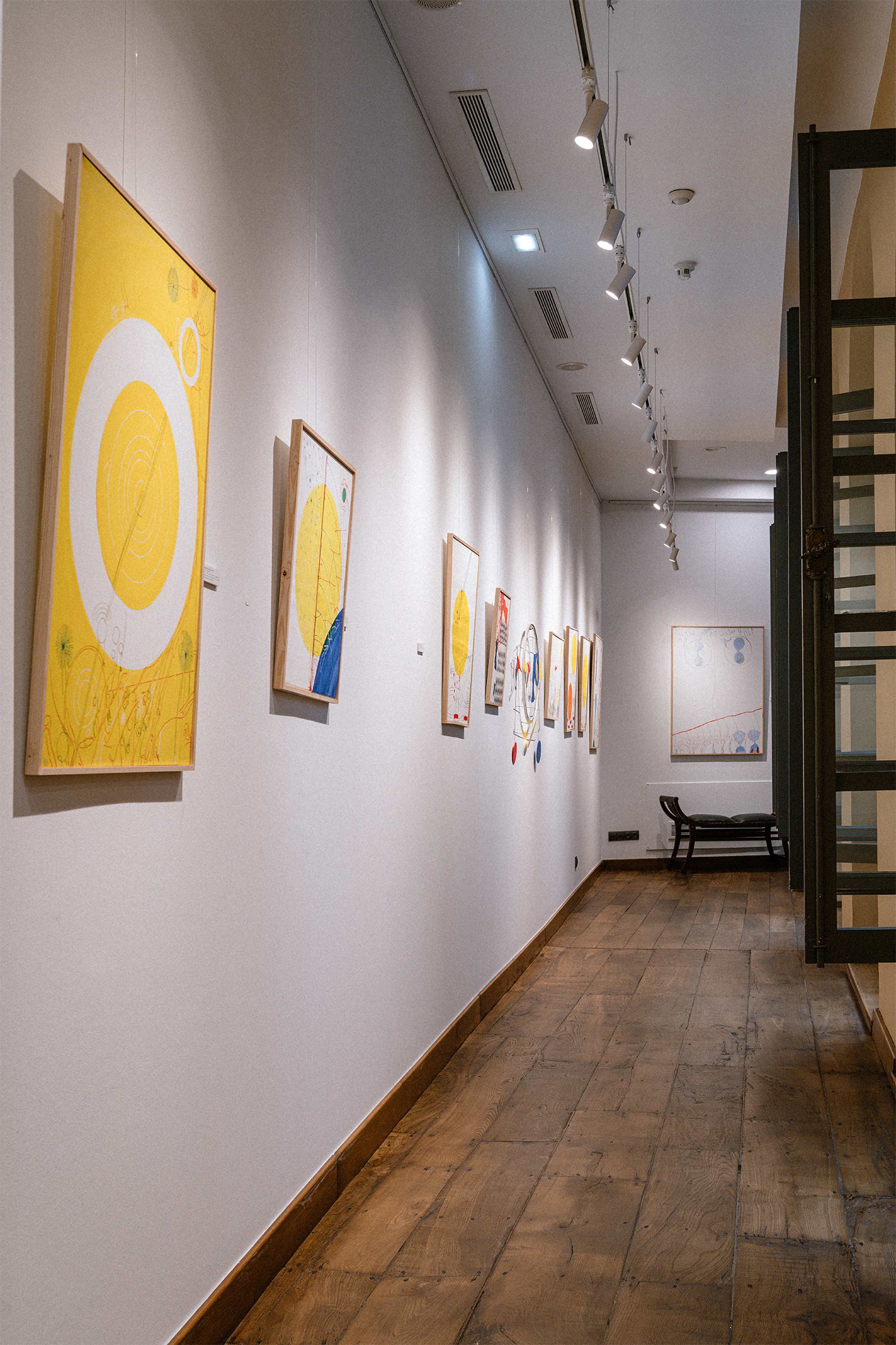 Abstract art exhibition in gallery with yellow paintings, wooden floor, track lighting. - Rojo - Palacio de Avilés Affiliated by Meliá, Avilés