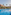 Tropical resort pool with palm trees, multi-story hotels, and elephant sculptures.