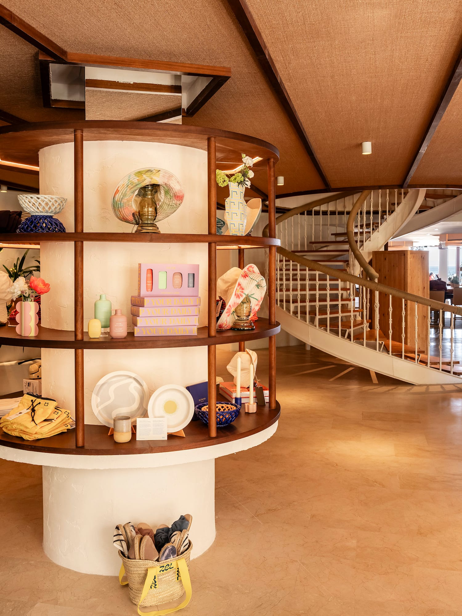 a spiral staircase with a circular shelf with objects on it