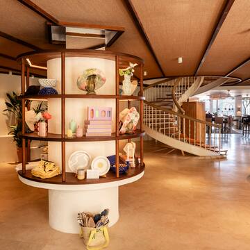 a spiral staircase with a circular shelf with objects on it