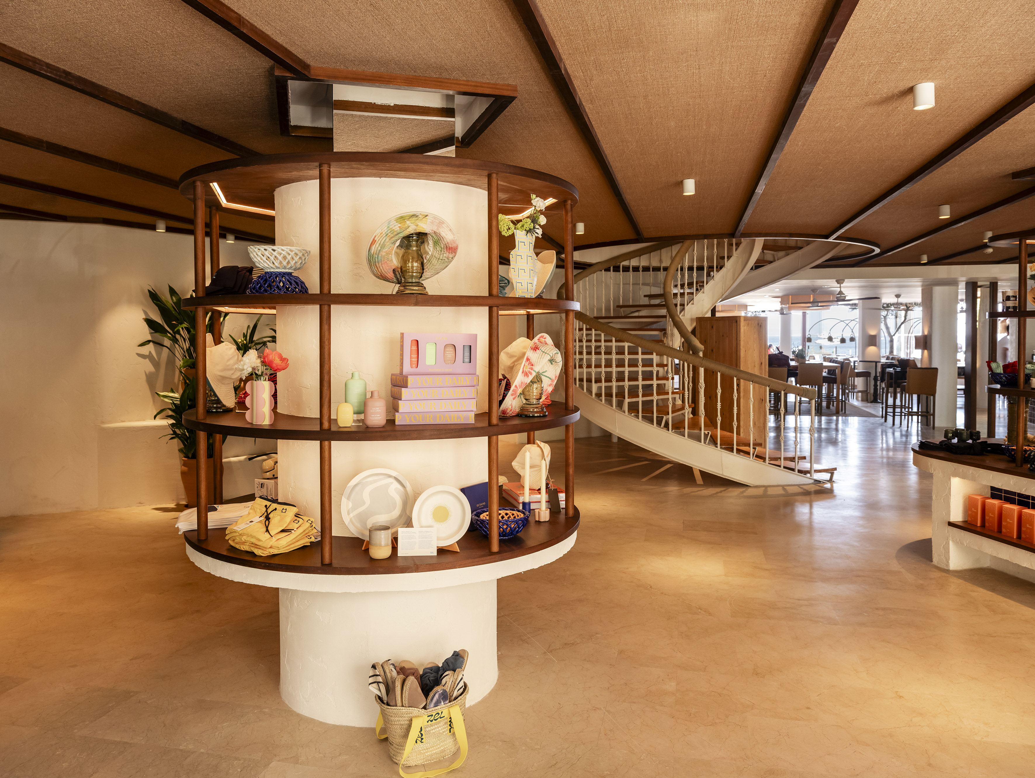 Boutique interior with circular product display and elegant spiral staircase.