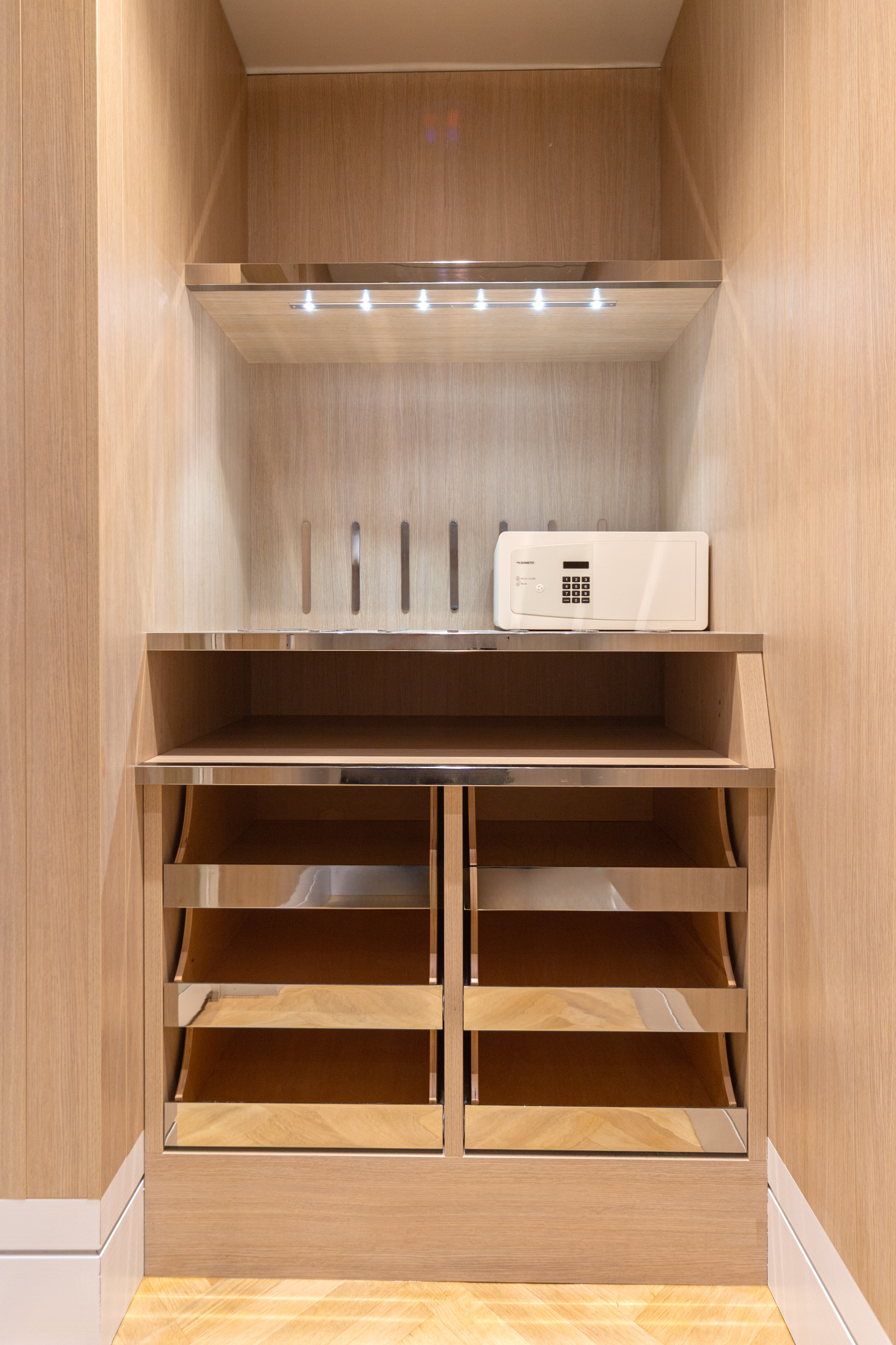 Modern light wood wardrobe with hotel safe, illuminated shelves, and drawers. - Supreme Room - Meliá Genova, جنوة