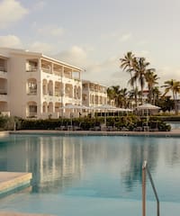 a pool with a building and palm trees