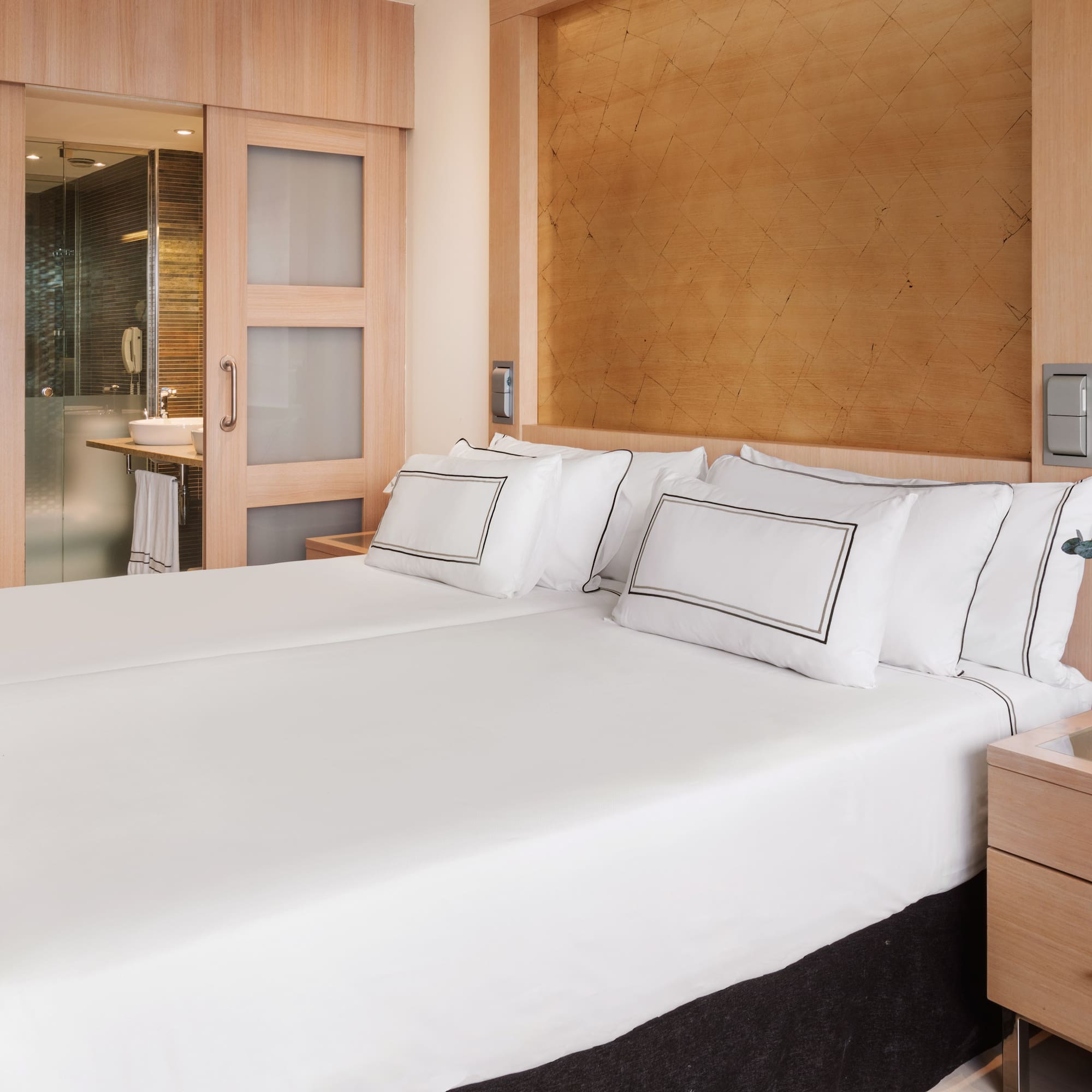 a bed with white sheets and a wood headboard