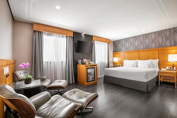 a room with a bed and chairs