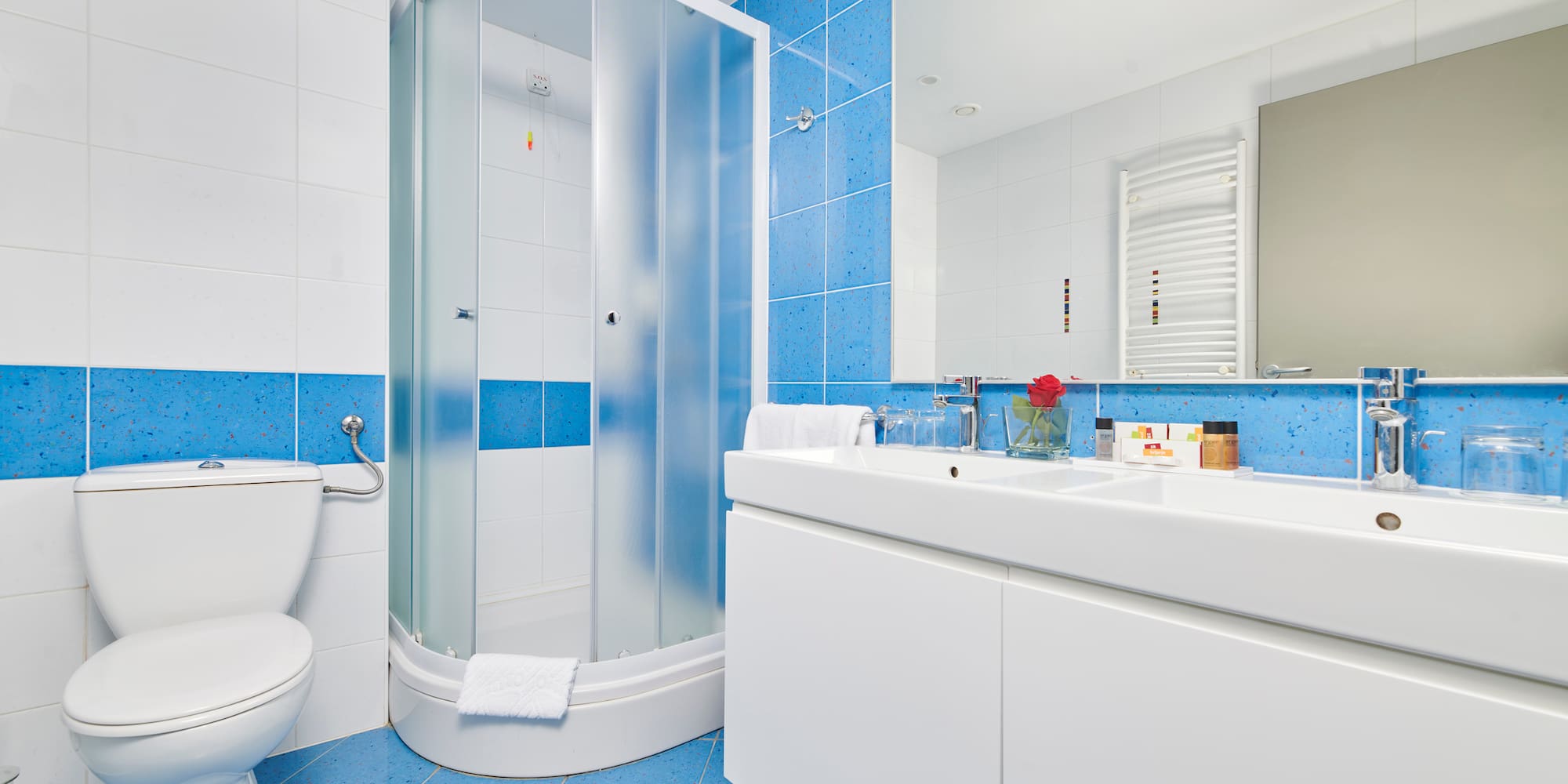 a bathroom with blue tile walls and a shower