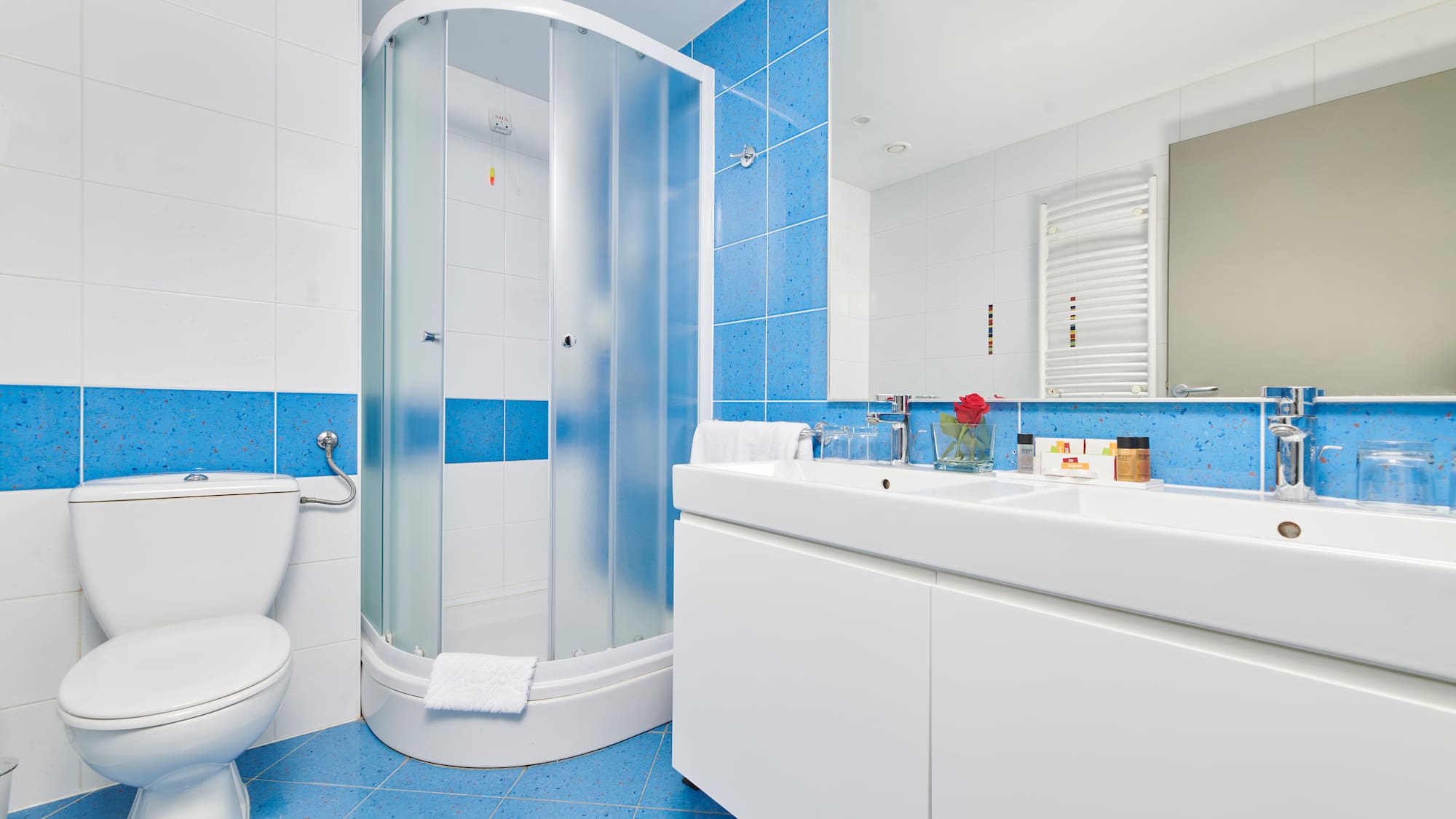 a bathroom with blue tile walls and a shower