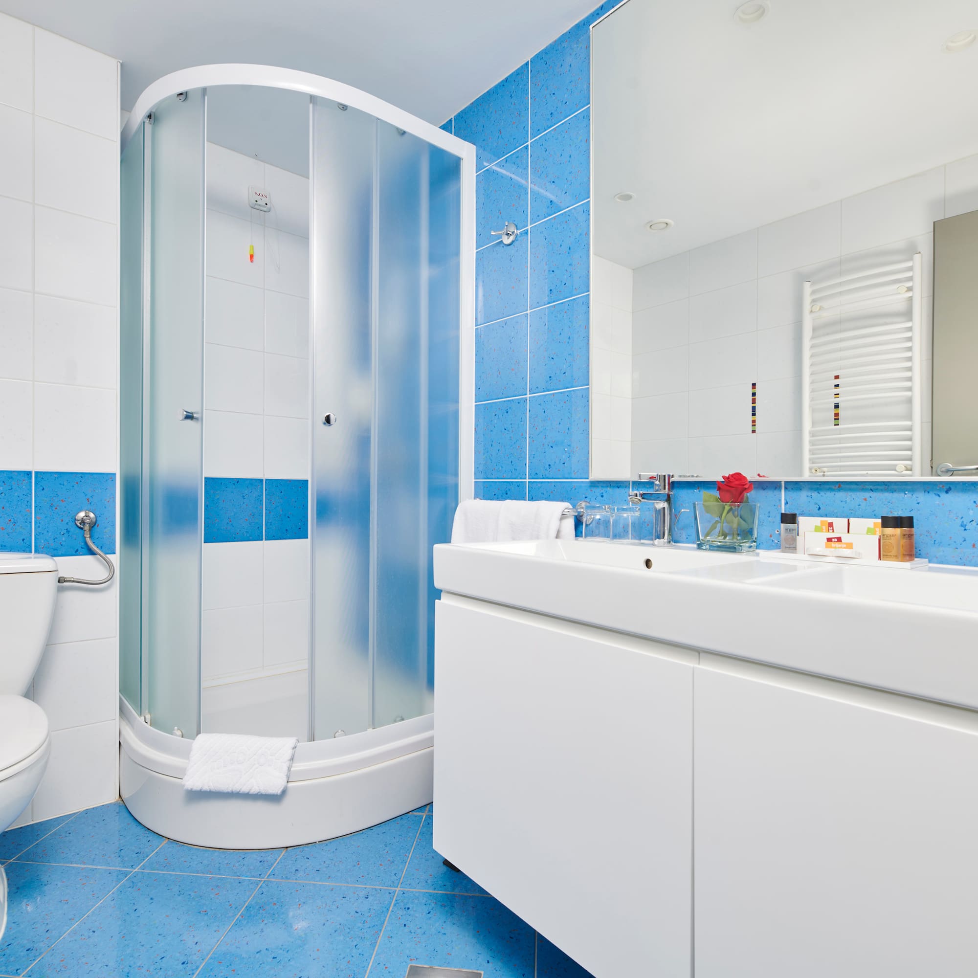 a bathroom with blue tile walls and a shower