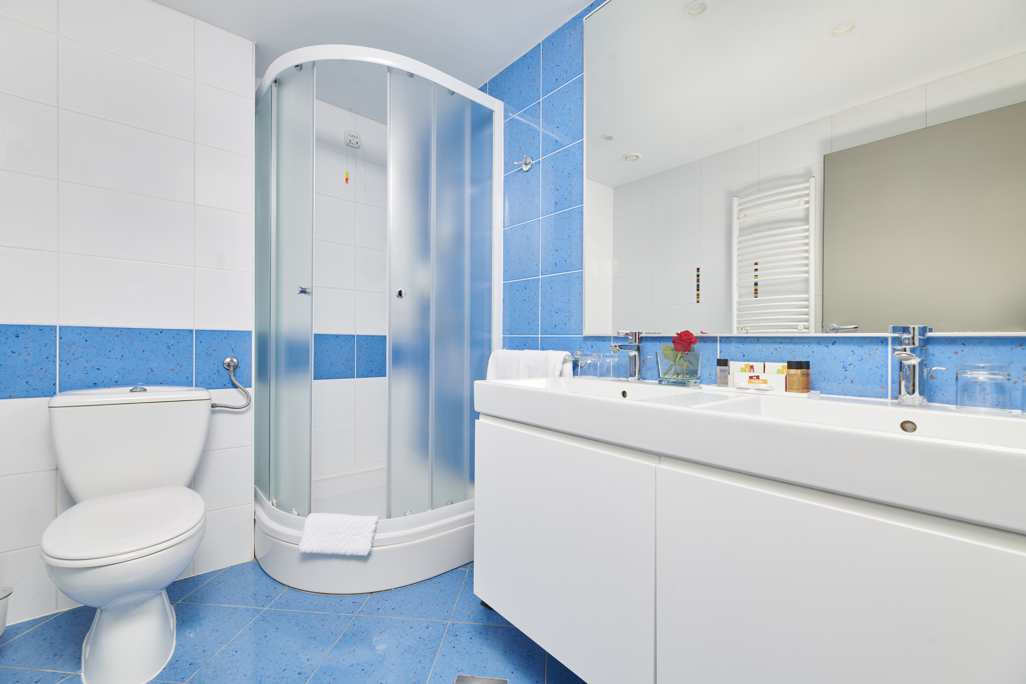 a bathroom with blue tile walls and a shower
