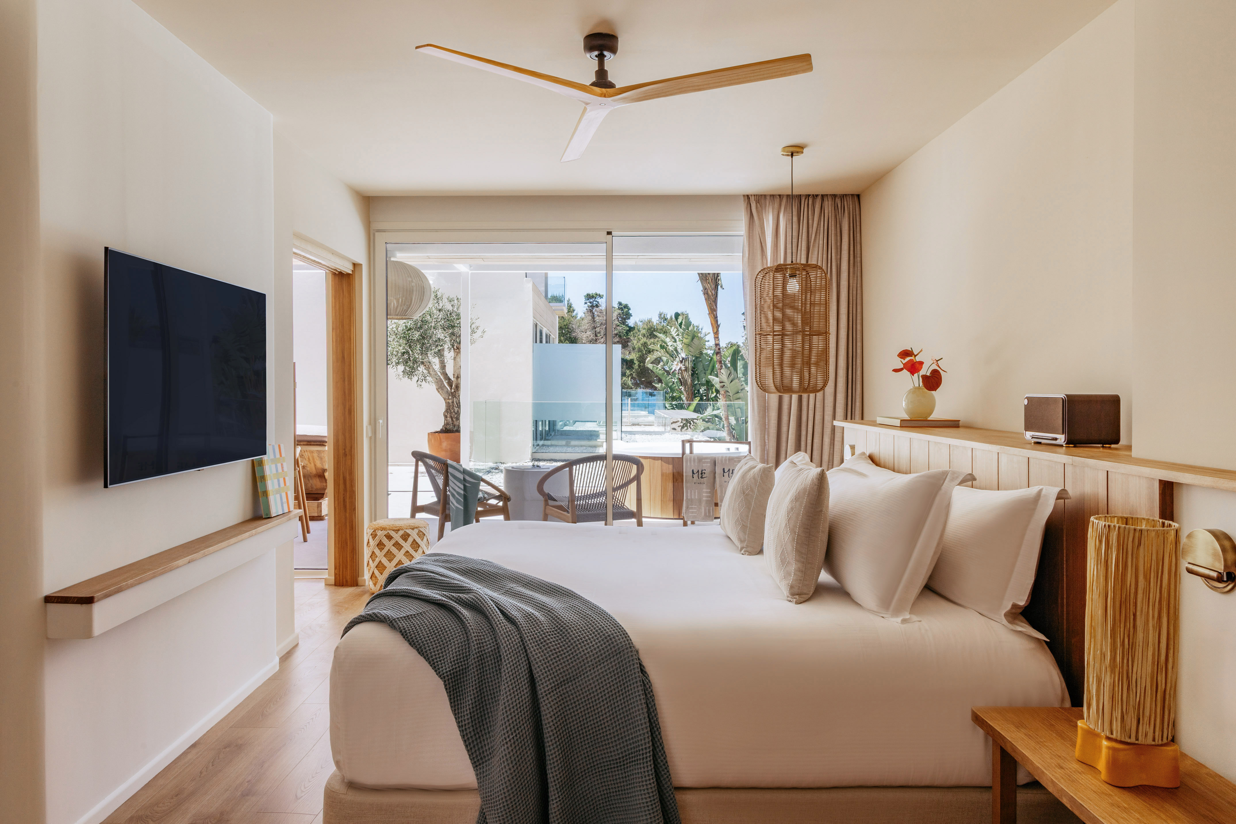 Modern hotel bedroom with private patio, outdoor pool, and wood accents.