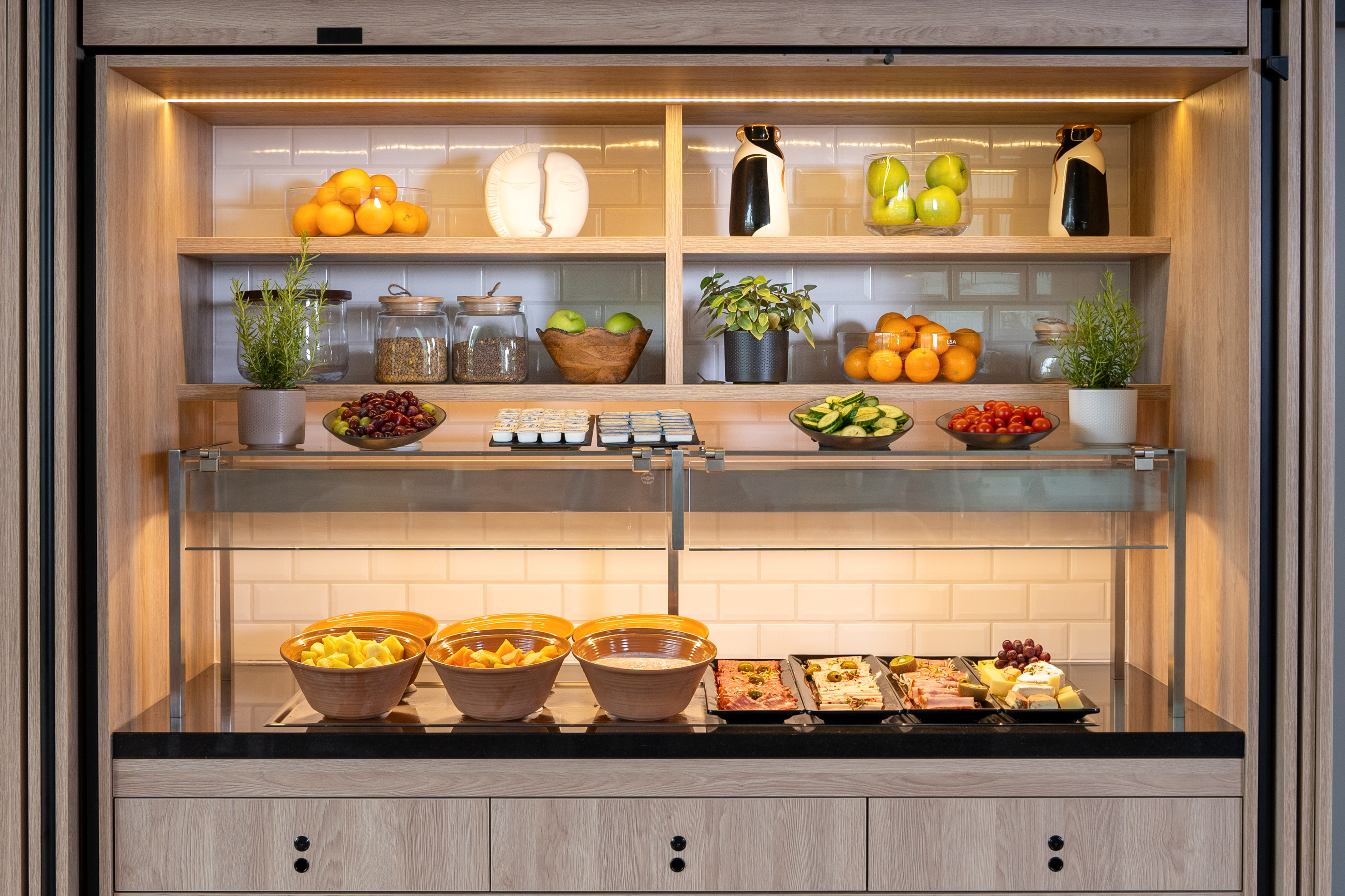 Fresh fruit, cold cuts, cheese, and vegetables on a modern hotel buffet.