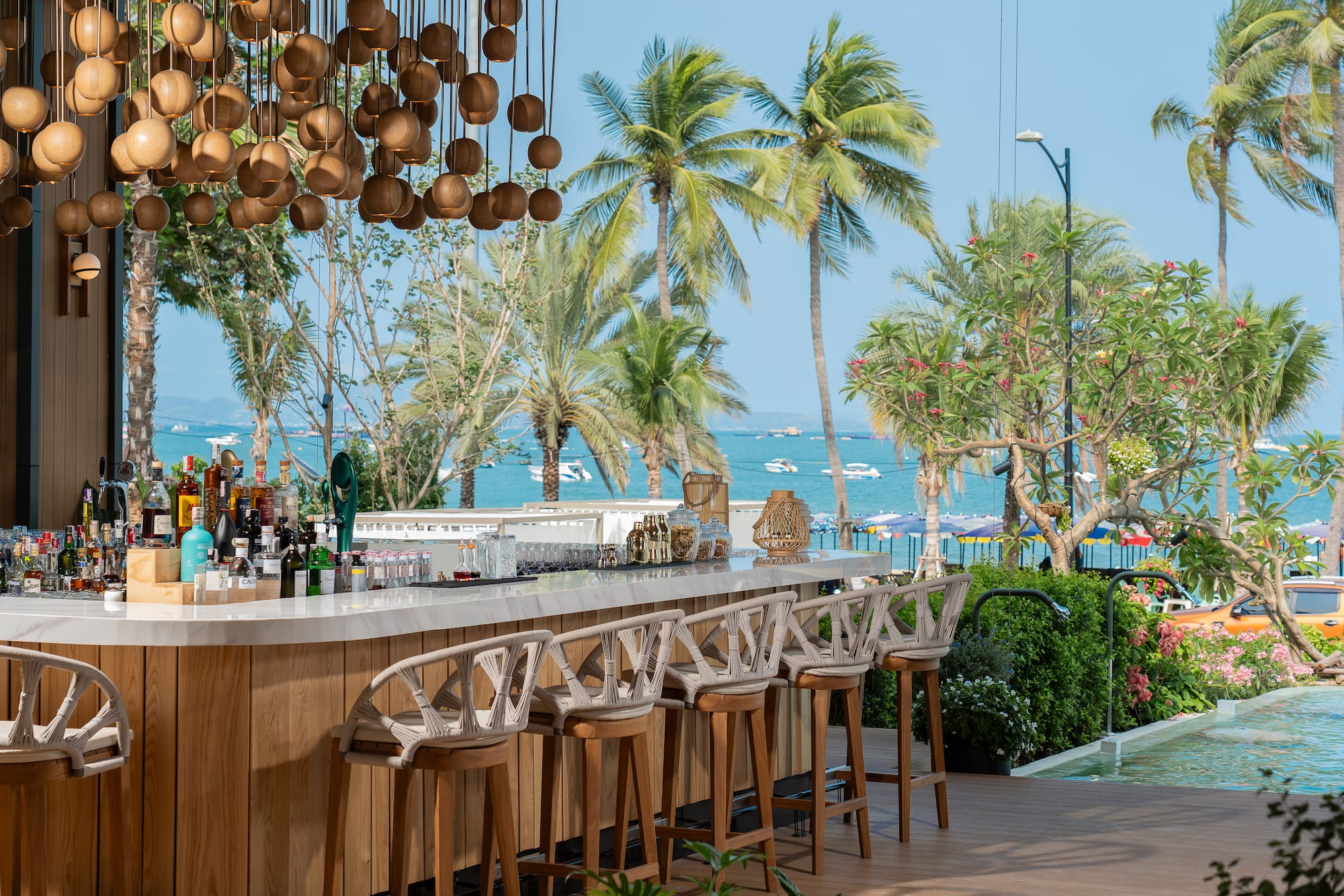 a bar with chairs and a pool in the background