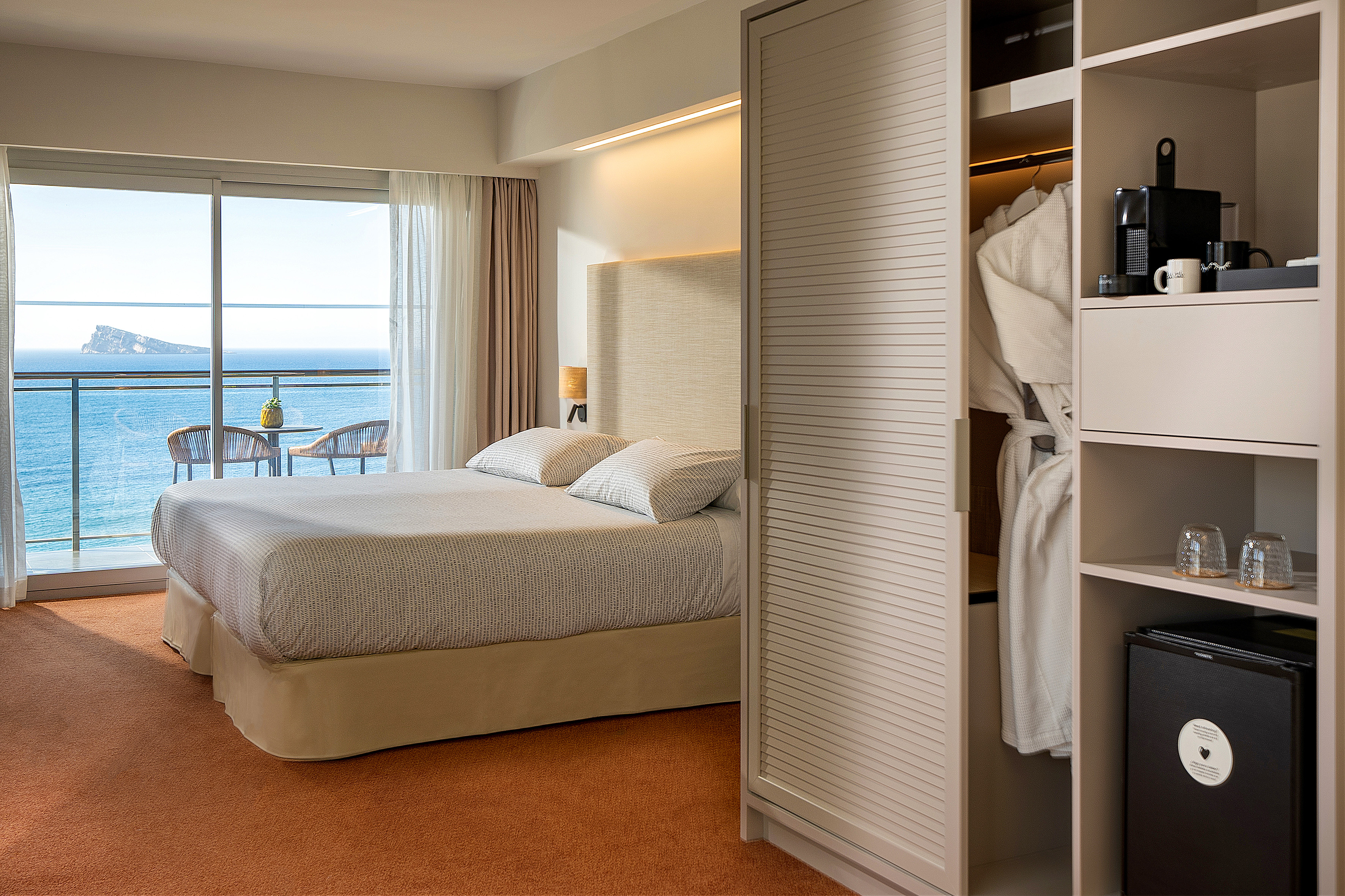Benidorm hotel room with sea view balcony and comfortable double bed.