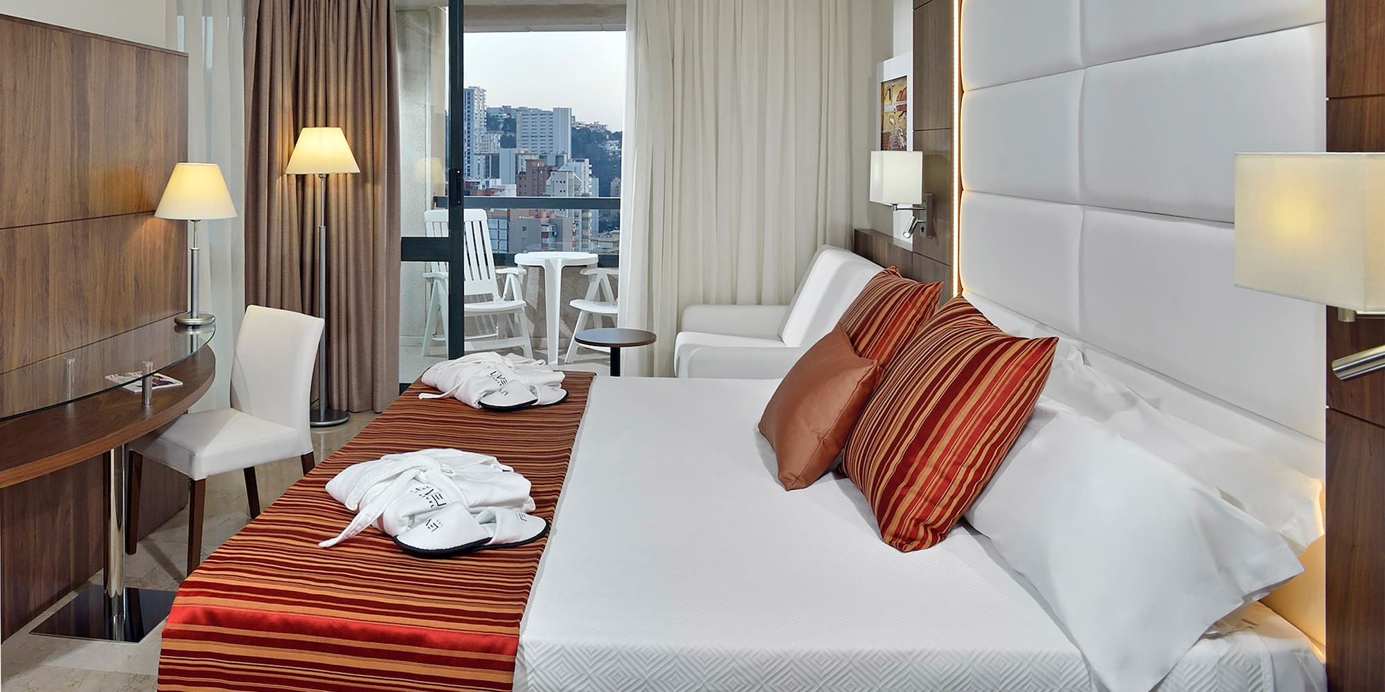 a hotel room with a bed and chairs