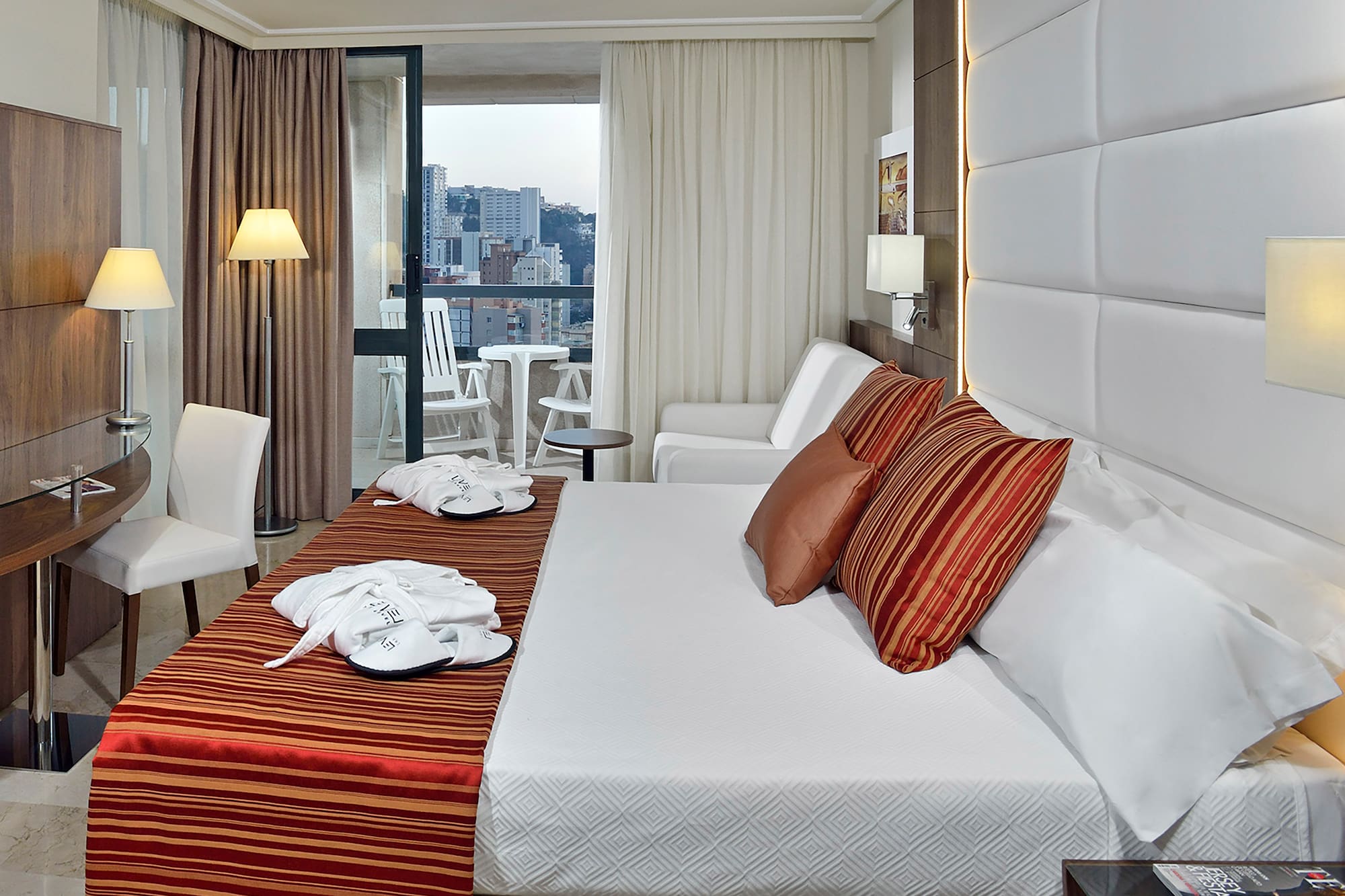 a hotel room with a bed and chairs