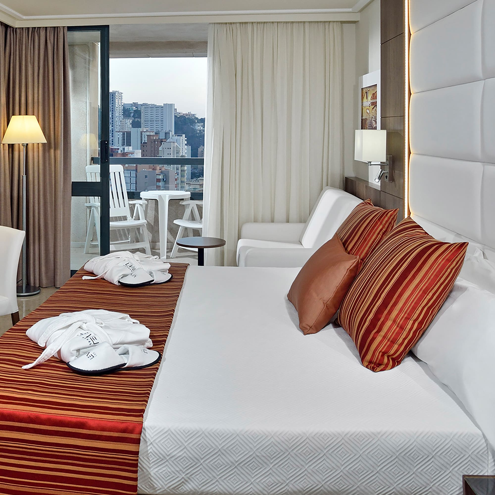 a hotel room with a bed and chairs