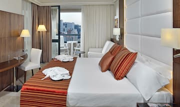 a hotel room with a bed and chairs
