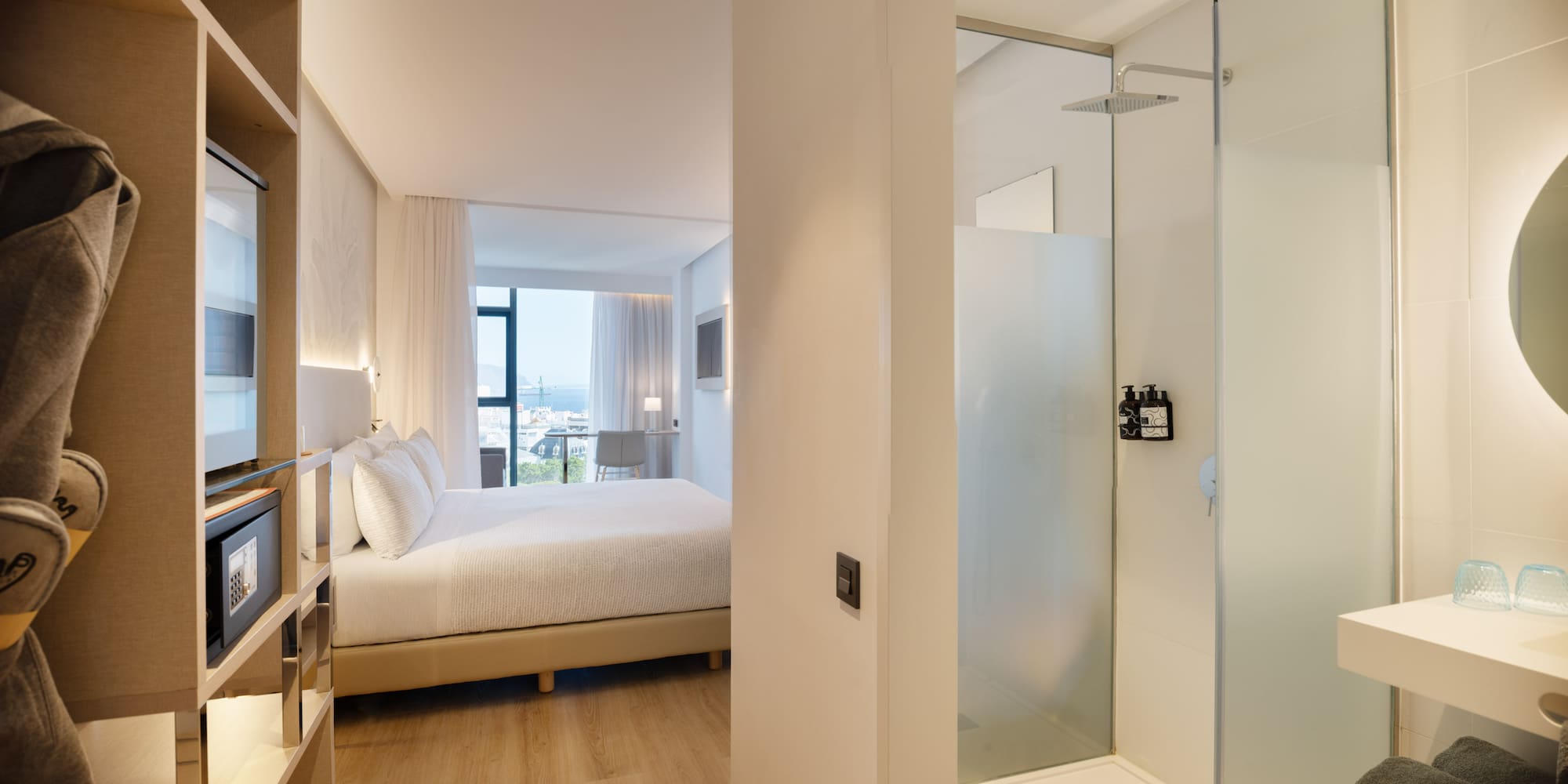 a bedroom with a glass shower and a bed