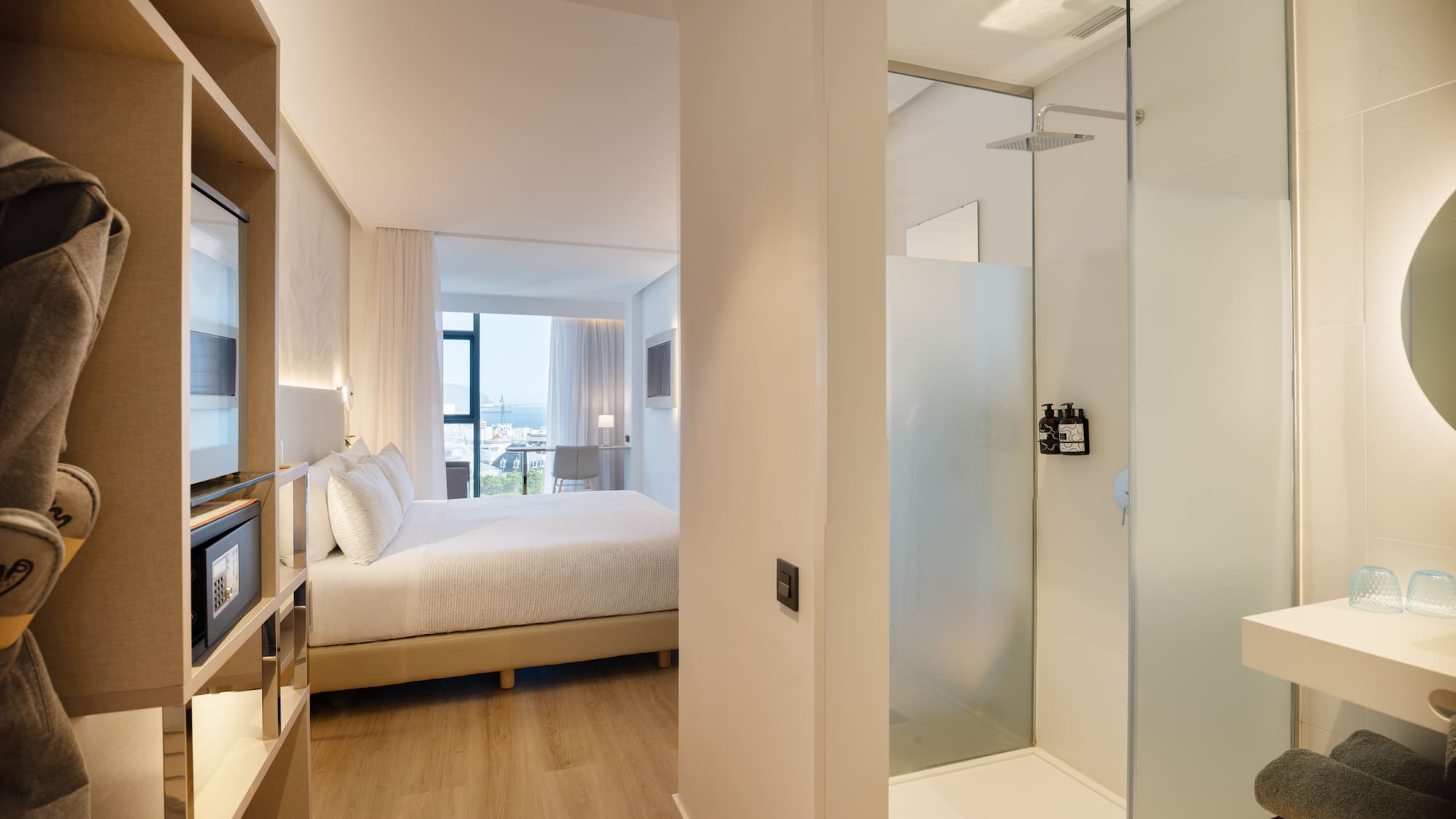 a bedroom with a glass shower and a bed
