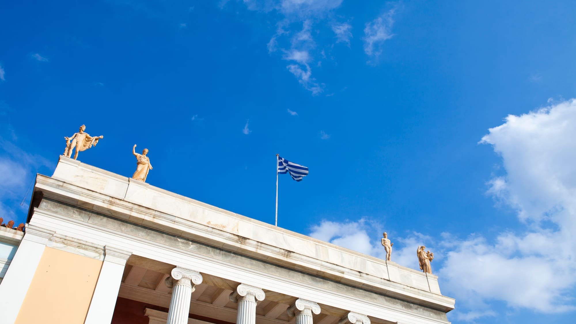 a building with columns and statues on top of it